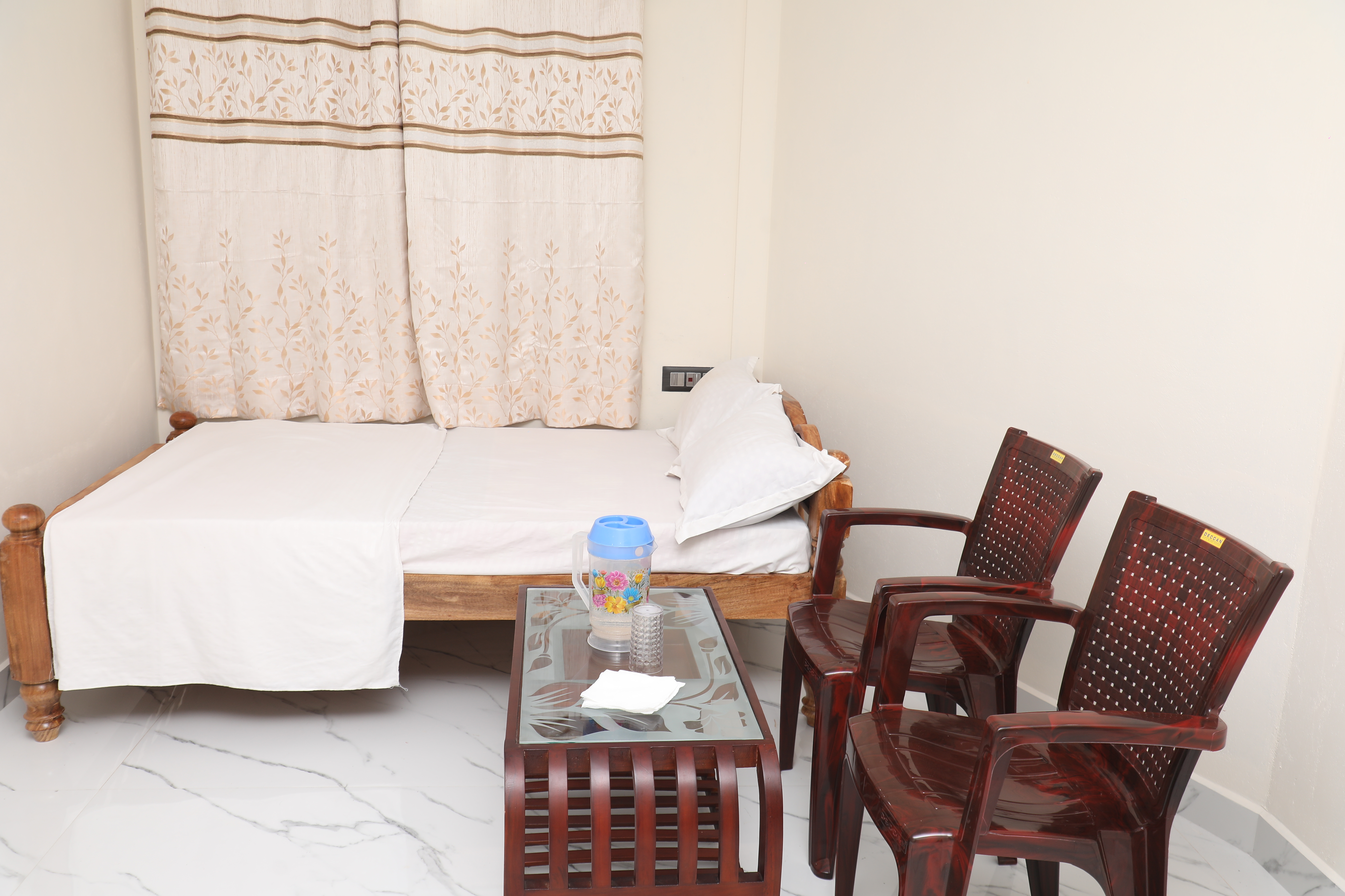 Double room with bed, chairs, and table at Nooji Homestay