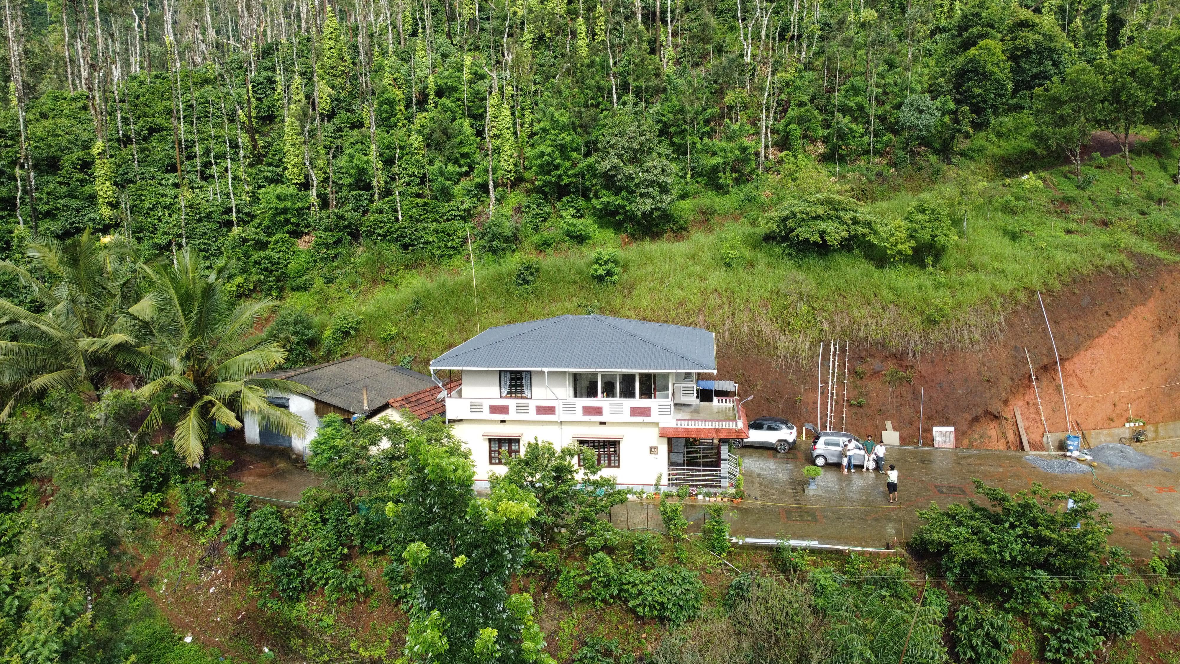 Aerial-style view of Nooji Homestay in a green hillside setting